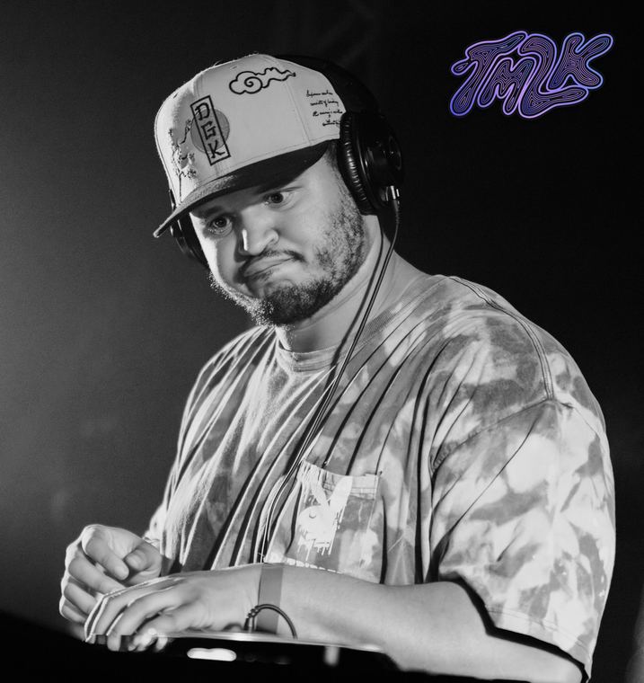 Black-and-white close-up of Cam in headphones at the decks